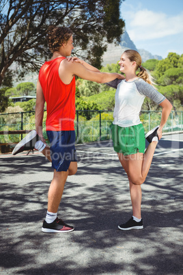 Man and woman stretching on road