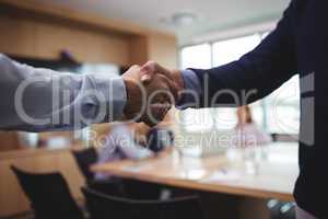 Business people shaking hands during meeting in board room