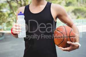 Midsection of  basketball player with holding bottle