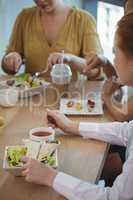 Female business colleagues having lunch at office cafeteria