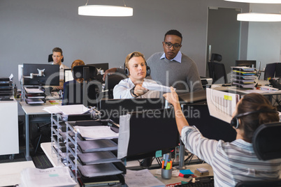 Businessman giving document to colleague working at office