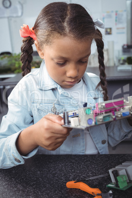 Focused elementary student examining circuit board