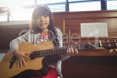 Portrait of girl practicing guitar