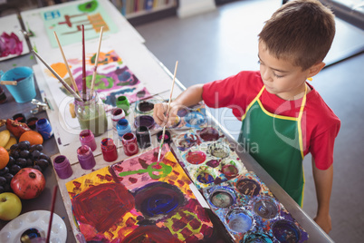 High angle view of boy painting at desk