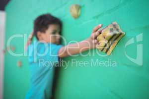 Boy climbing green wall