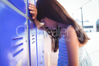 Side view of sad girl leaning on lockers
