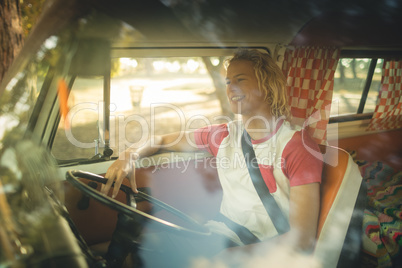 Smiling man sitting in camper van