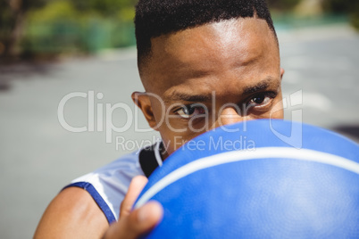 Close up portrait of male teenager holding basketball