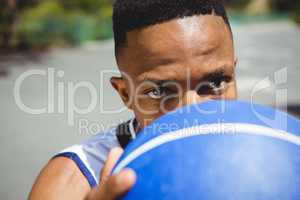 Close up portrait of male teenager holding basketball