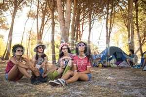 Young female friends sitting at campsite