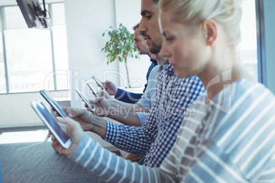 Business colleagues in row using mobile phones