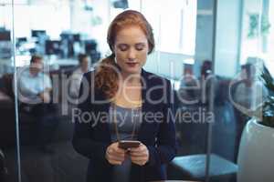 Young businesswoman using mobile phone at office
