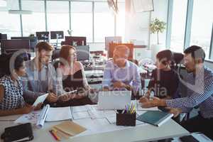 High angle view of creative business colleagues discussing around desk