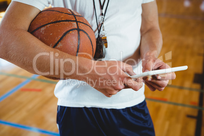 Close up midsection of male coach using digital tablet