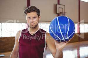 Portrait of serious basketball player holding ball