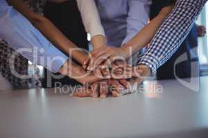 Business colleagues stacking their hands on desk