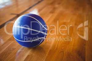 Close up of blue basketball on hardwood floor