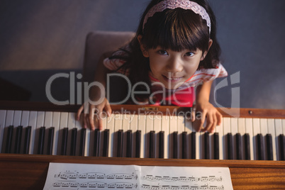 Overhead portrait of girl playing piano in classroom