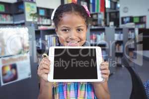 Smiling girl showing digital tablet in library