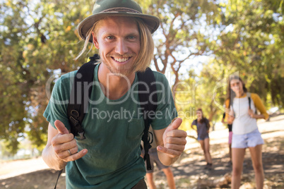 Portrait of man gesturing with friends in background