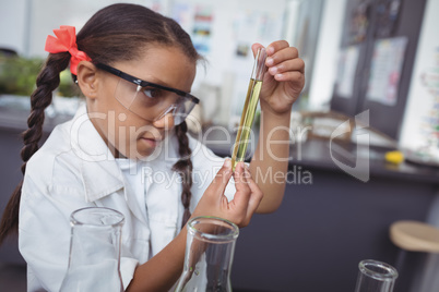 Concentrated student examining yellow chemical in test tube at laboratory