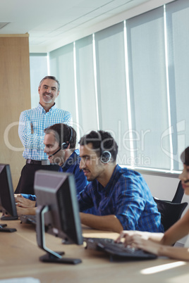 Portrait of smiling supervisor with business team at call center