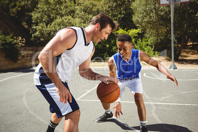 Happy friends playing basketball