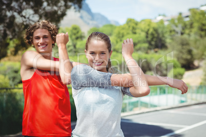 Portrait of happy friends exercising on road