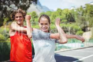 Portrait of happy friends exercising on road