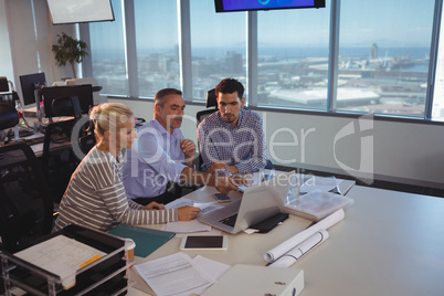 Business partners discussing over laptop in meeting