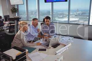 Business partners discussing over laptop in meeting