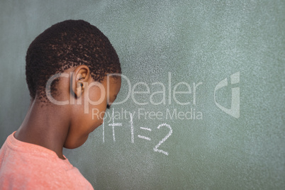 Boy standing by chalkboard