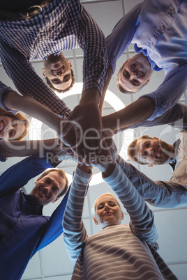 Directly below portrait of business colleagues stacking hands at office