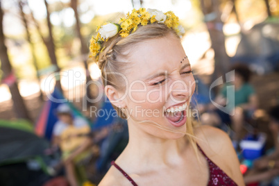 Young woman shouting with eyes closed at campsite