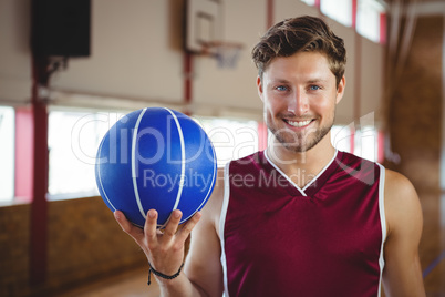 Portrait of smiling confident player holding basketball