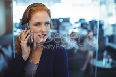 Thoughtful businesswoman taking on mobile phone