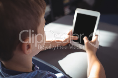 Boy using digital tablet at desk