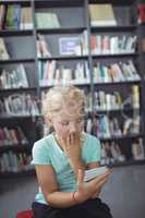 Surprised girl looking at mobile phone in library