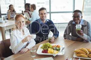 Portrait of smiling business colleagues sitting at breakfast table