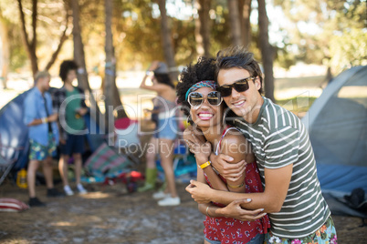 Portrait of friends embracing at campsite