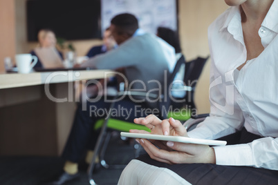 Mid section of businesswoman using digital tablet at office