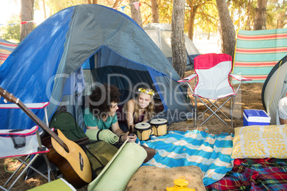 Couple talking while relaxing in tent