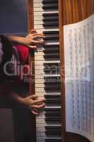 Overhead view of girl playing piano in classroom