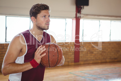 Man practicing basketball in court