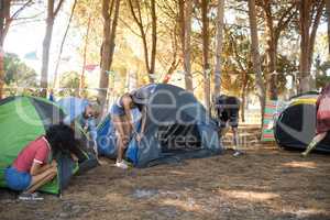 Friends setting up their tents together on field