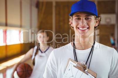 Portrait of smiling male coach with basketball player