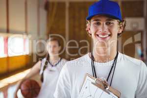 Portrait of smiling male coach with basketball player