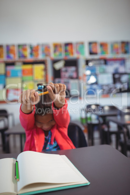 Girl stretching hands while sitting at desk