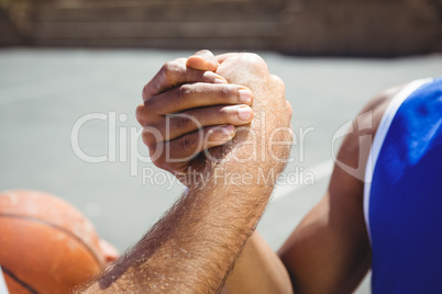 Cropped image of basketball players holding hands