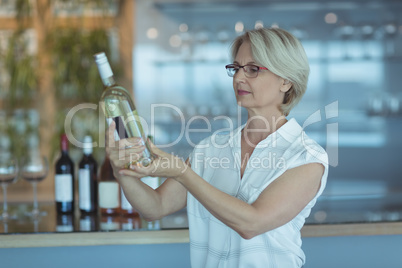 Businesswoman looking at winebottle